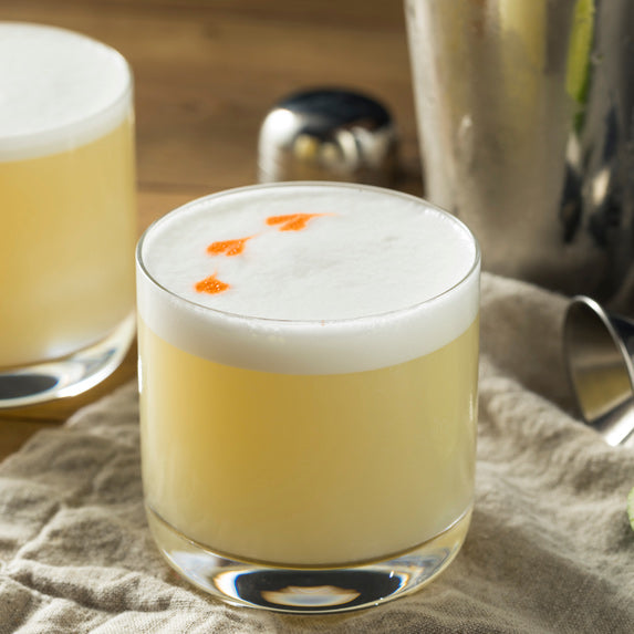 a whiskey sour sitting on a kitchen table