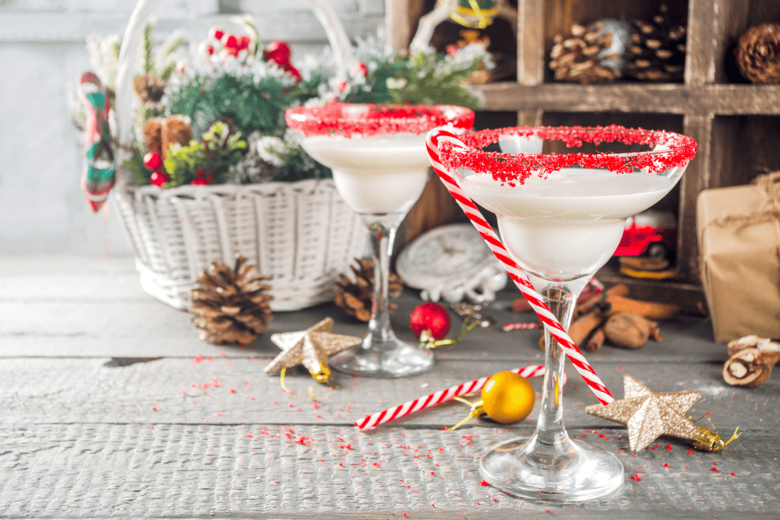 Festive white holiday cocktails with red sugar rims and candy canes.