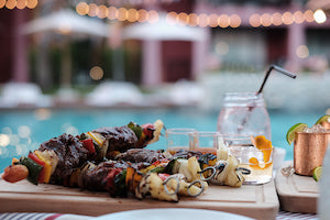 a plate of barbecue alongside a mezcal old fashioned and a Moscow mule