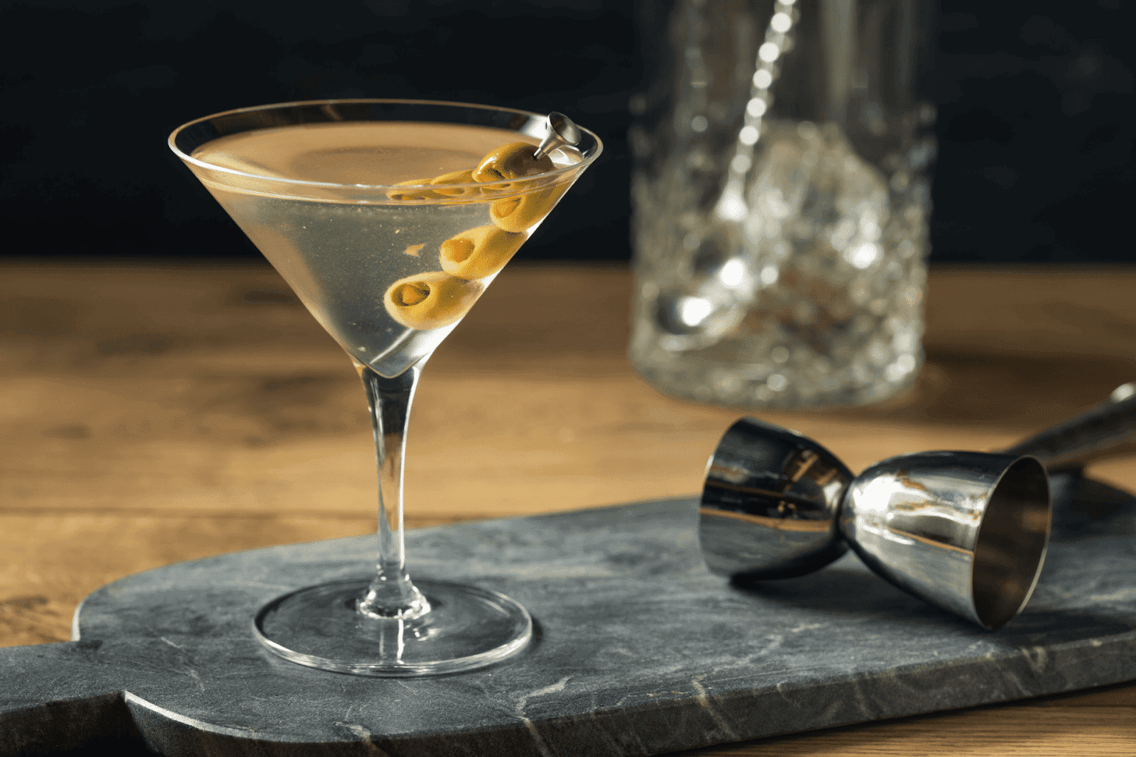 Classic martini in a glass with three green olives on a skewer