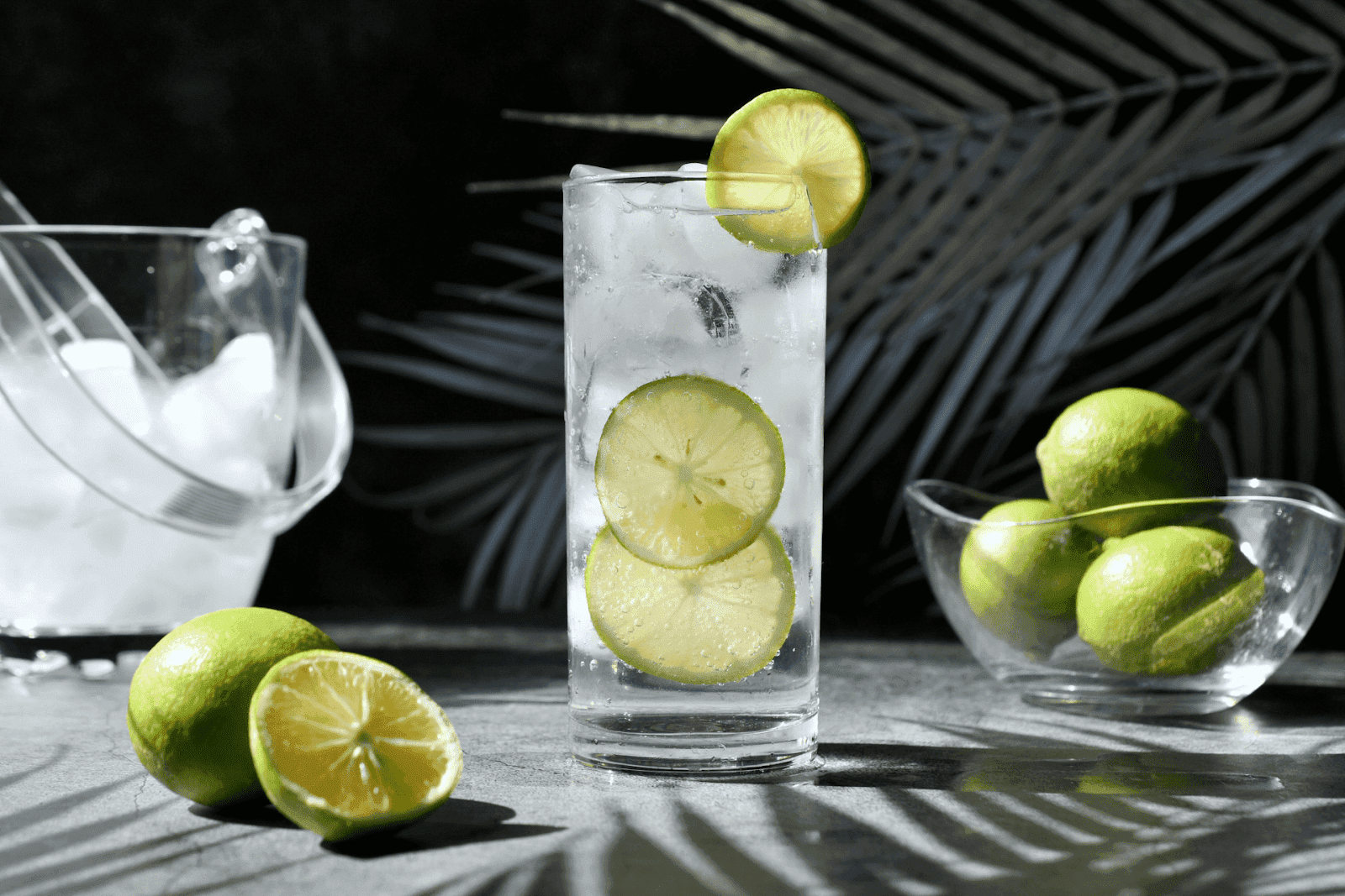 Refreshing lime cocktail with ice and lime slices in a tall glass