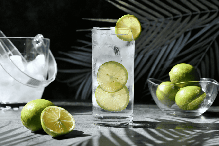 Refreshing lime cocktail with ice and lime slices in a tall glass
